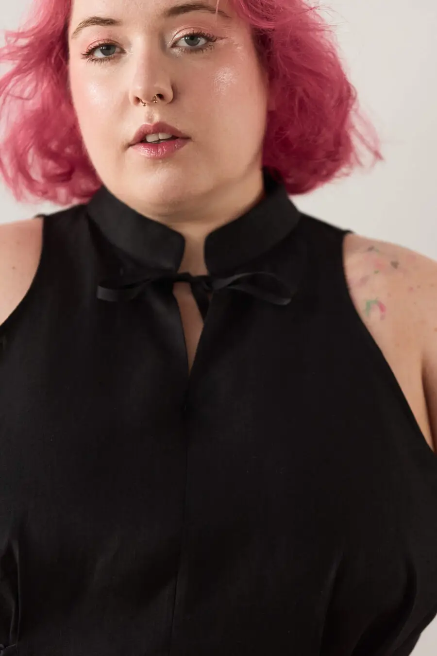 Yvonne sleeveless corset shirt in black - A sleeveless halter-style shirt made from pink gingham with a structured silhouette and corset-inspired lacing at the waist.