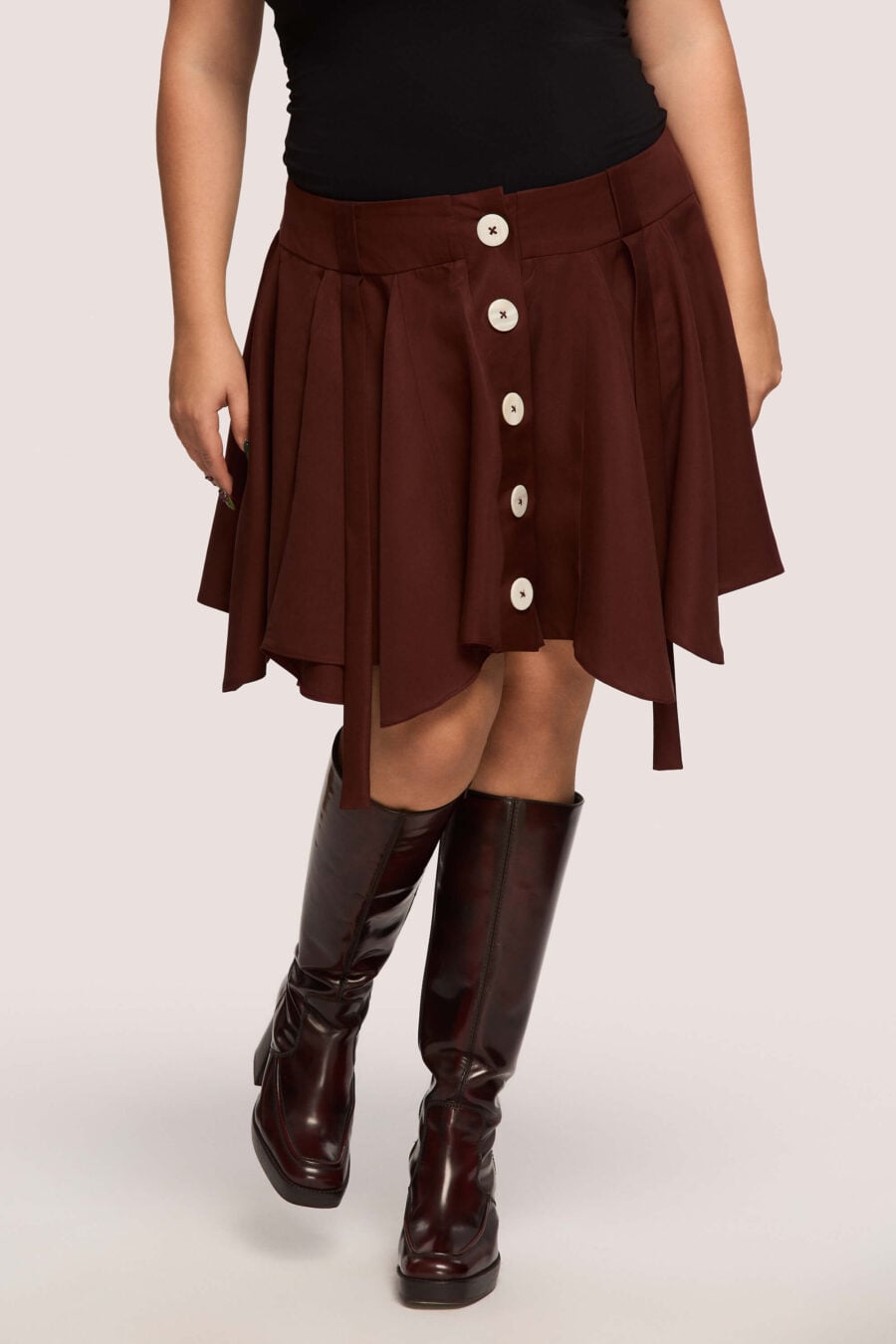 Anonymous mini skirt in bordeaux - Designed to move with you. Sharp lines, soft edges, a little mischief pleated into the hem. A skirt that swings, not for attention, but for joy.