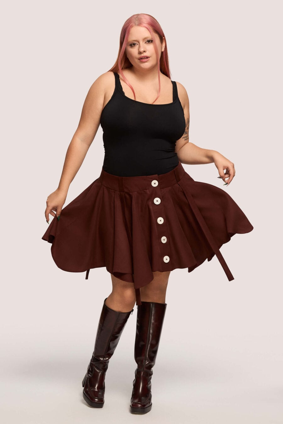 Anonymous mini skirt in bordeaux - Designed to move with you. Sharp lines, soft edges, a little mischief pleated into the hem. A skirt that swings, not for attention, but for joy.
