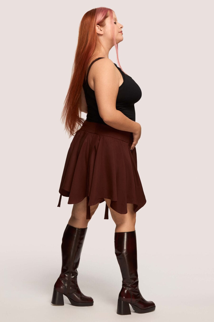 Anonymous mini skirt in bordeaux - Designed to move with you. Sharp lines, soft edges, a little mischief pleated into the hem. A skirt that swings, not for attention, but for joy.