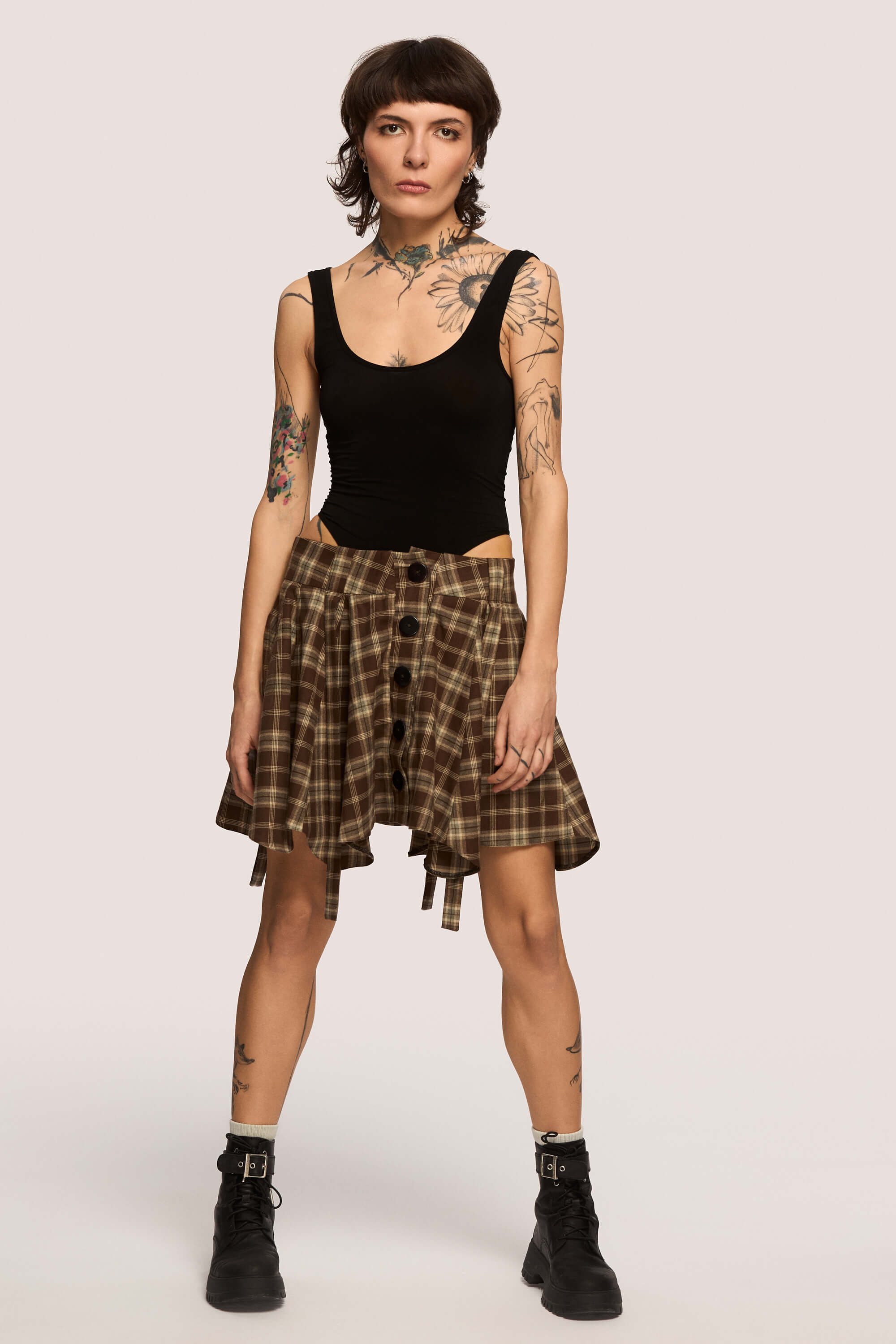 Winter 2025 Anonymous Mini Skirt In Chestnut Plaid 1 Anonymous Mini Skirt In Chestnut Plaid Anonymous mini skirt in chestnut plaid Designed to move with you. Sharp lines, soft edges, a little mischief pleated into the hem. A skirt that swings, not for attention, but for joy.
