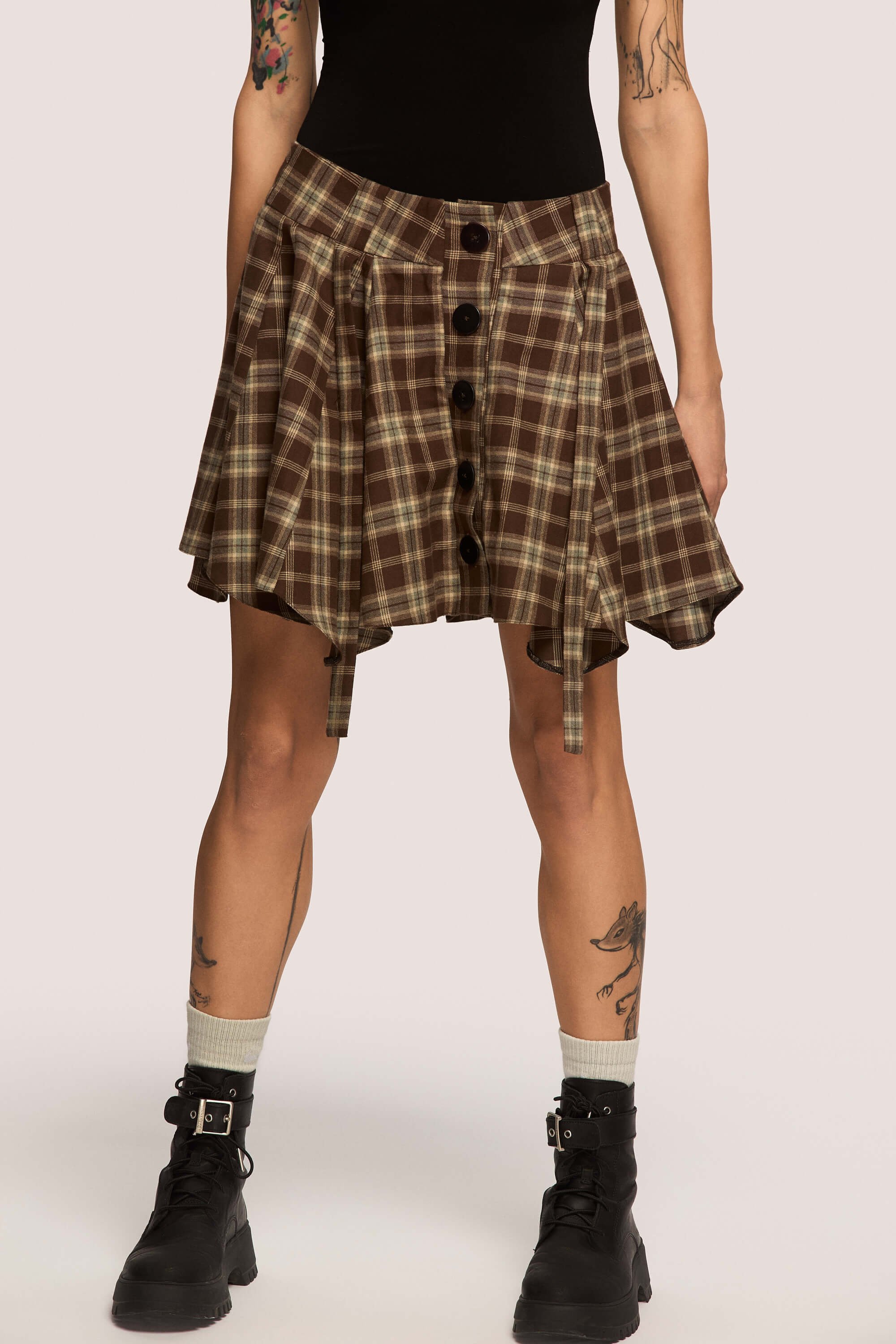 Winter 2025 Anonymous Mini Skirt In Chestnut Plaid 2 Anonymous Mini Skirt In Chestnut Plaid Anonymous mini skirt in chestnut plaid Designed to move with you. Sharp lines, soft edges, a little mischief pleated into the hem. A skirt that swings, not for attention, but for joy.