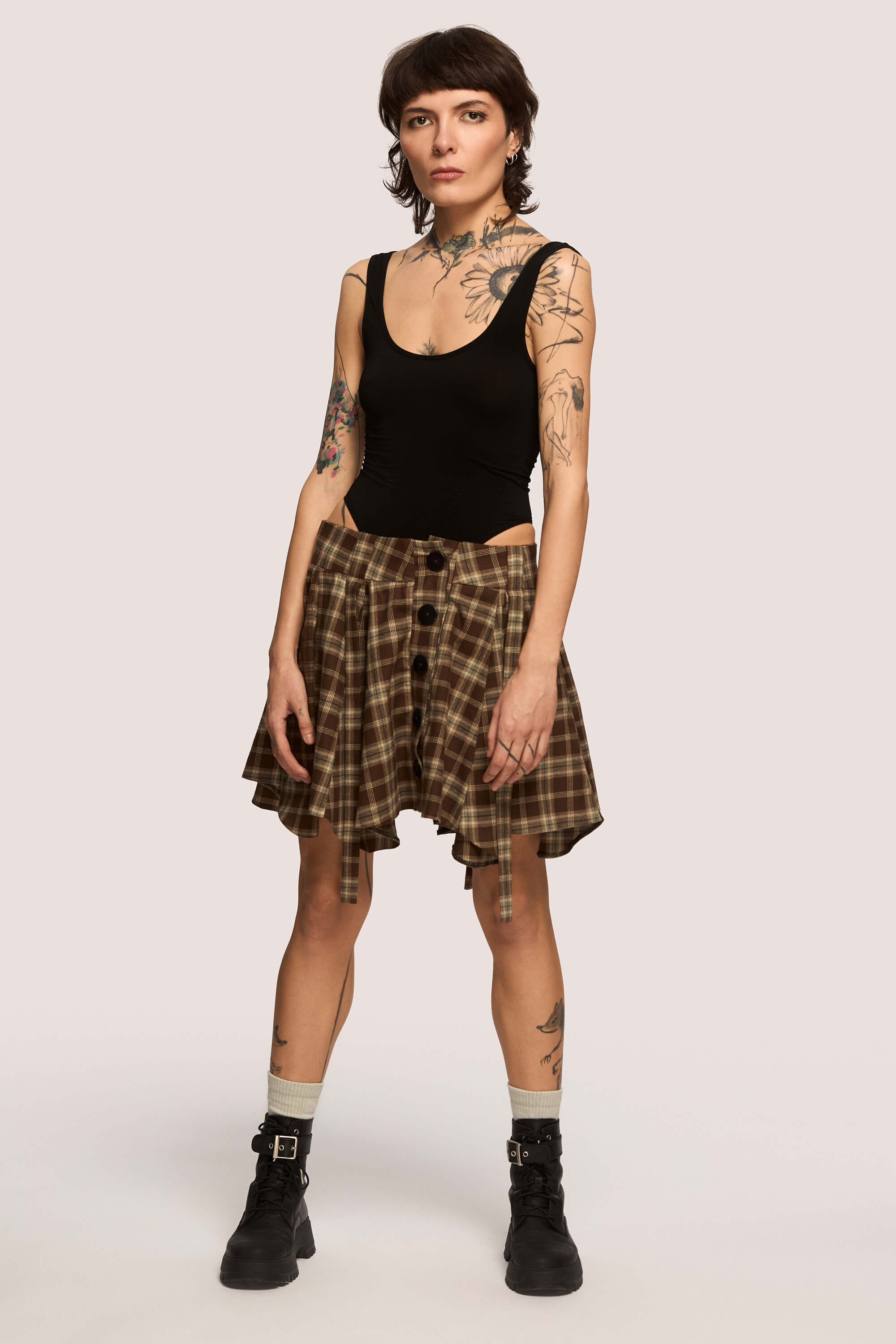 Winter 2025 Anonymous Mini Skirt In Chestnut Plaid 3 Anonymous Mini Skirt In Chestnut Plaid Anonymous mini skirt in chestnut plaid Designed to move with you. Sharp lines, soft edges, a little mischief pleated into the hem. A skirt that swings, not for attention, but for joy.
