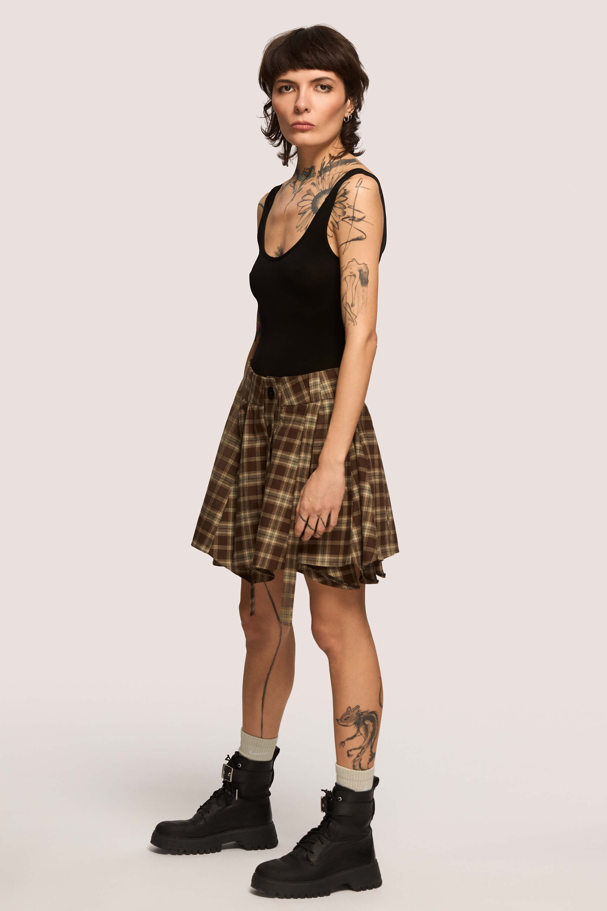 Winter 2025 Anonymous Mini Skirt In Chestnut Plaid 4 Anonymous Mini Skirt In Chestnut Plaid Anonymous mini skirt in chestnut plaid Designed to move with you. Sharp lines, soft edges, a little mischief pleated into the hem. A skirt that swings, not for attention, but for joy.