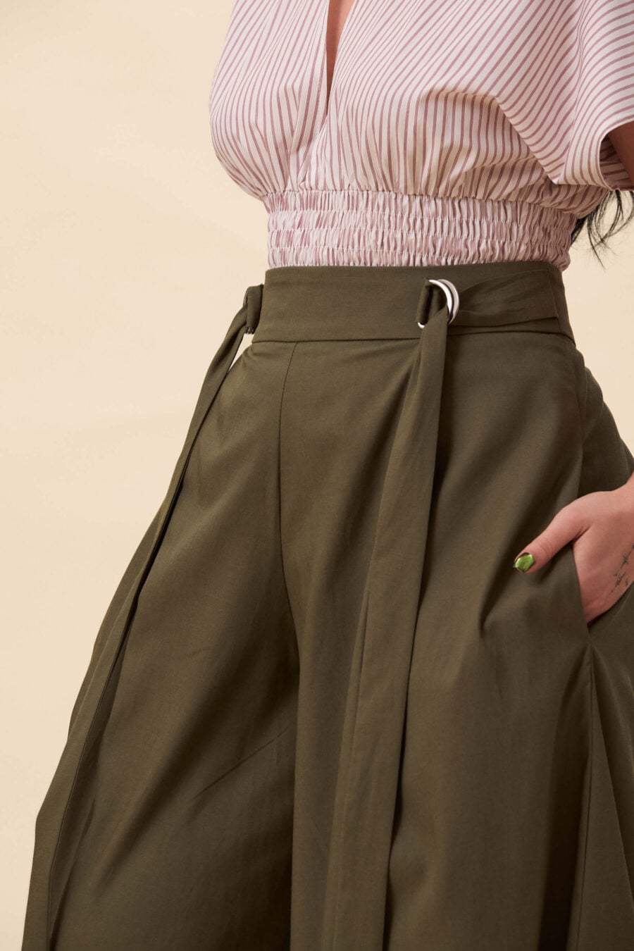 Amelia Peabody palazzo pants in olive green - A full, elongated line shaped by a high, structured waist. The fit is adjusted through a double D-ring belt, introducing function without excess detail. From there, the trousers fall wide and uninterrupted.