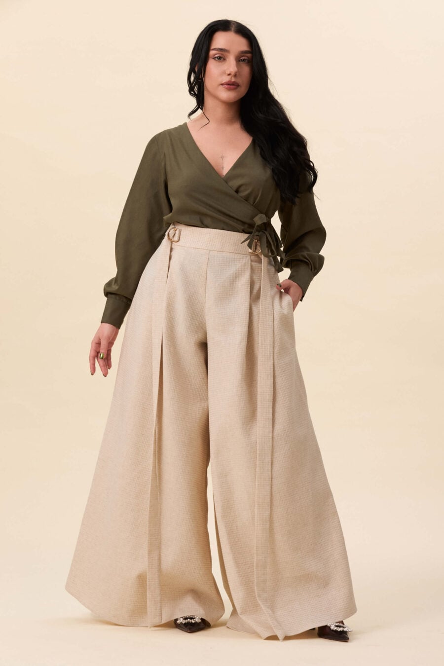 Amelia Peabody palazzo pants in textured beige  A full, elongated line shaped by a high, structured waist. The fit is adjusted through a double Dring belt, introducing function without excess detail. From there, the trousers fall wide and uninterrupted.