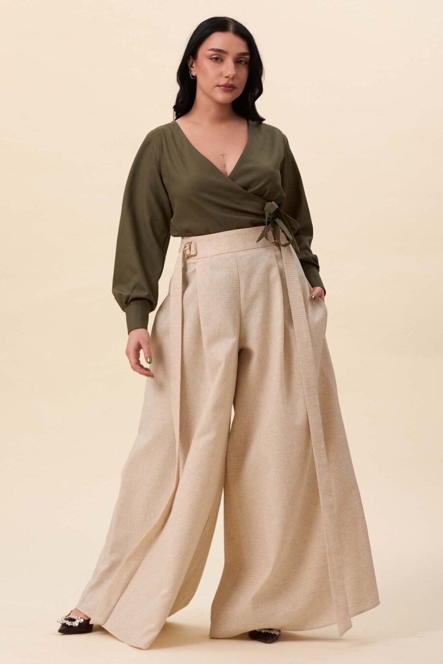 Amelia Peabody palazzo pants in textured beige - A full, elongated line shaped by a high, structured waist. The fit is adjusted through a double D-ring belt, introducing function without excess detail. From there, the trousers fall wide and uninterrupted.