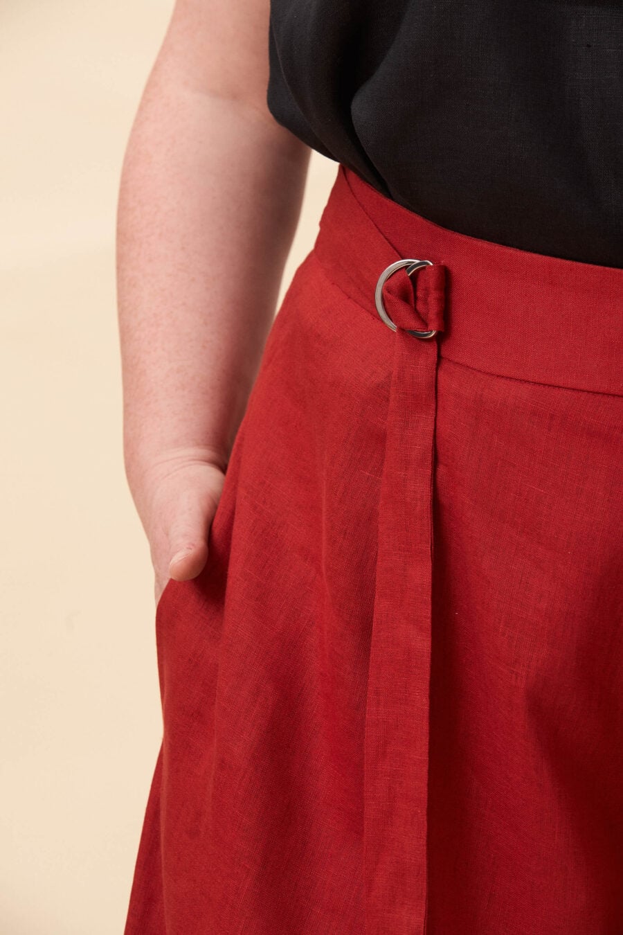 Amelia Peabody palazzo pants in tomato red - A full, elongated line shaped by a high, structured waist. The fit is adjusted through a double D-ring belt, introducing function without excess detail. From there, the trousers fall wide and uninterrupted.