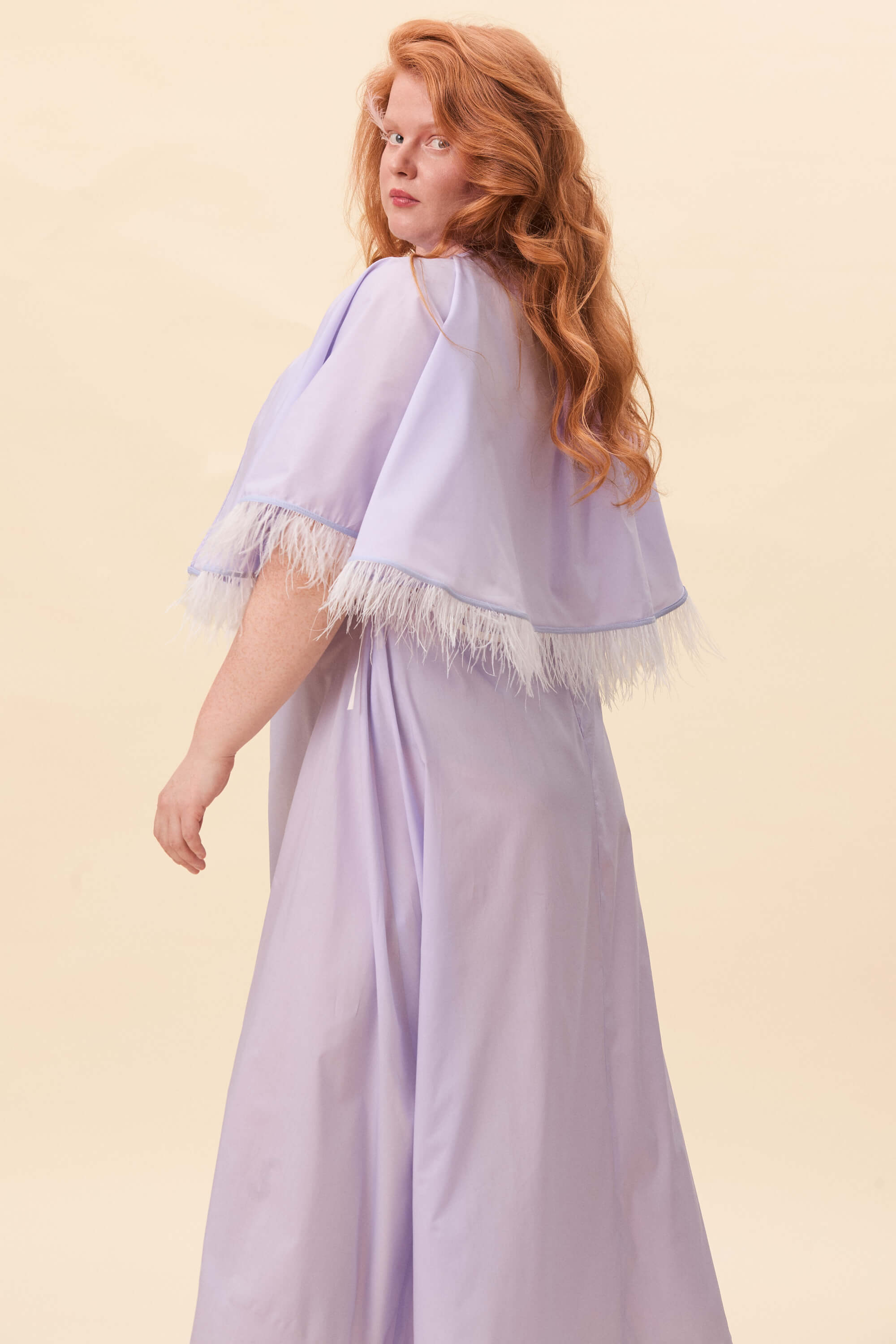 Spring 2026 Birds Of A Feather Cape In Lavender Voille 2 Birds Of A Feather Cape In Lavender Voille Birds of a Feather cape in lavender voille Cut in a short, flared silhouette that rests lightly on the shoulders. The cape ties at the neck, creating a clean opening through the front. Along the edge, a feather trim introduces texture and subtle motion. Balanced between structure and softness.
