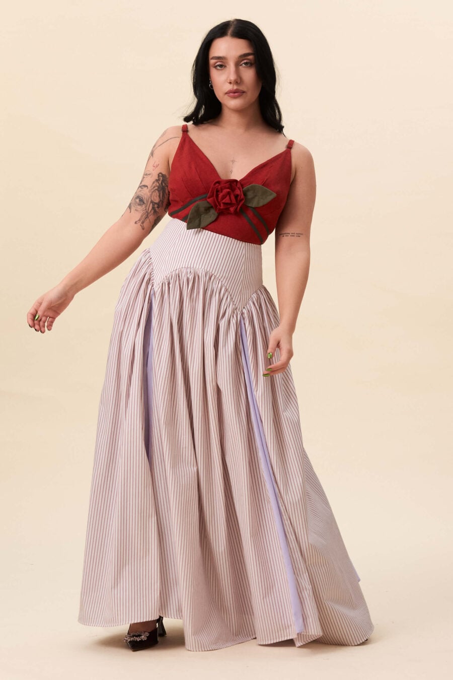 Cordelia Gray maxi skirt in red stripes - The waist holds a fitted structure before releasing into a full, gathered skirt. Contrasting panels at the front and back shape the silhouette, introducing variation and rhythm as the garment moves.
