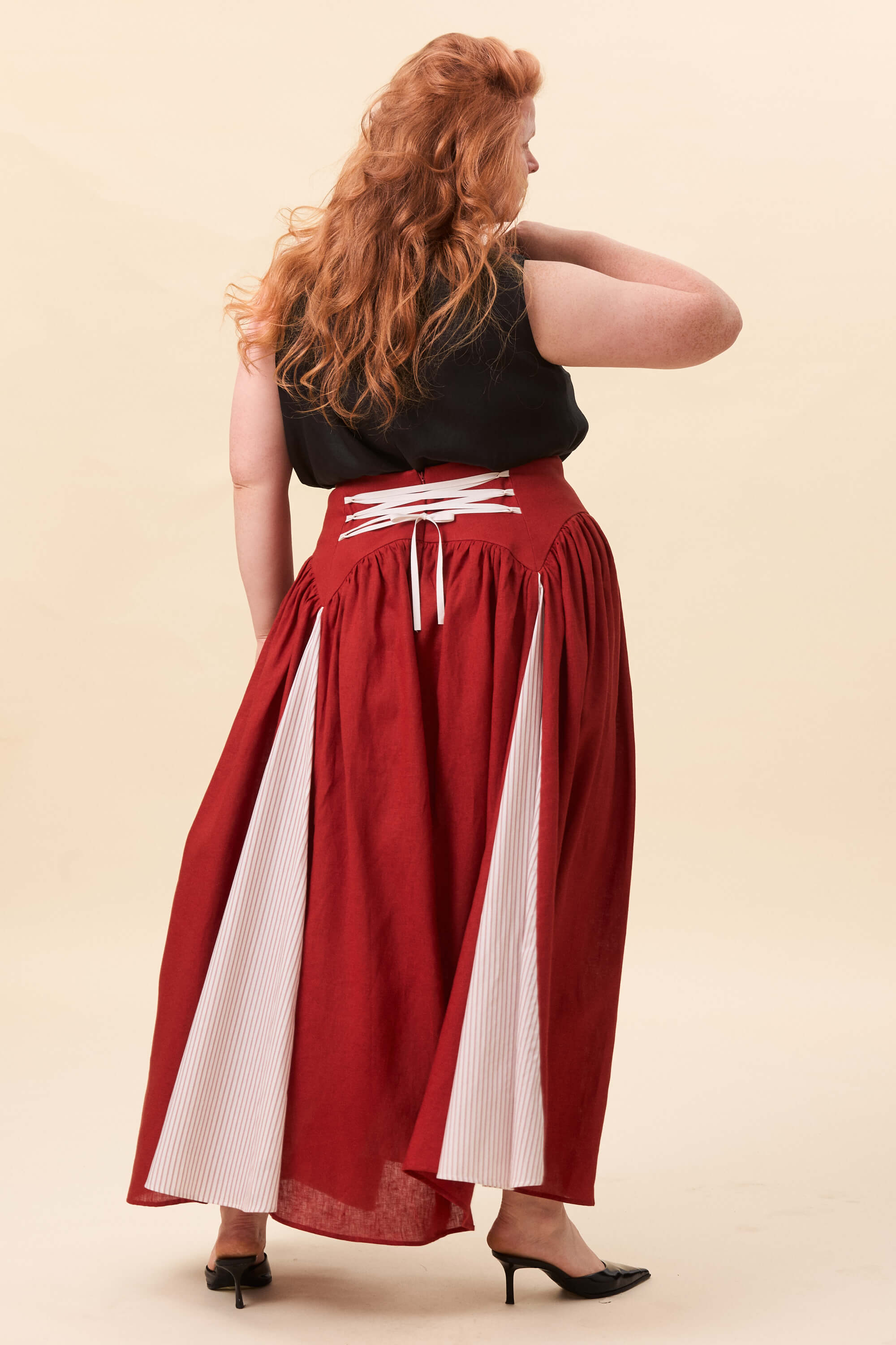 Spring 2026 Cordelia Gray Maxi Skirt In Tomato Red 2 Cordelia Gray Maxi Skirt In Tomato Red Cordelia Gray maxi skirt in tomato red The waist holds a fitted structure before releasing into a full, gathered skirt. Contrasting panels at the front and back shape the silhouette, introducing variation and rhythm as the garment moves.