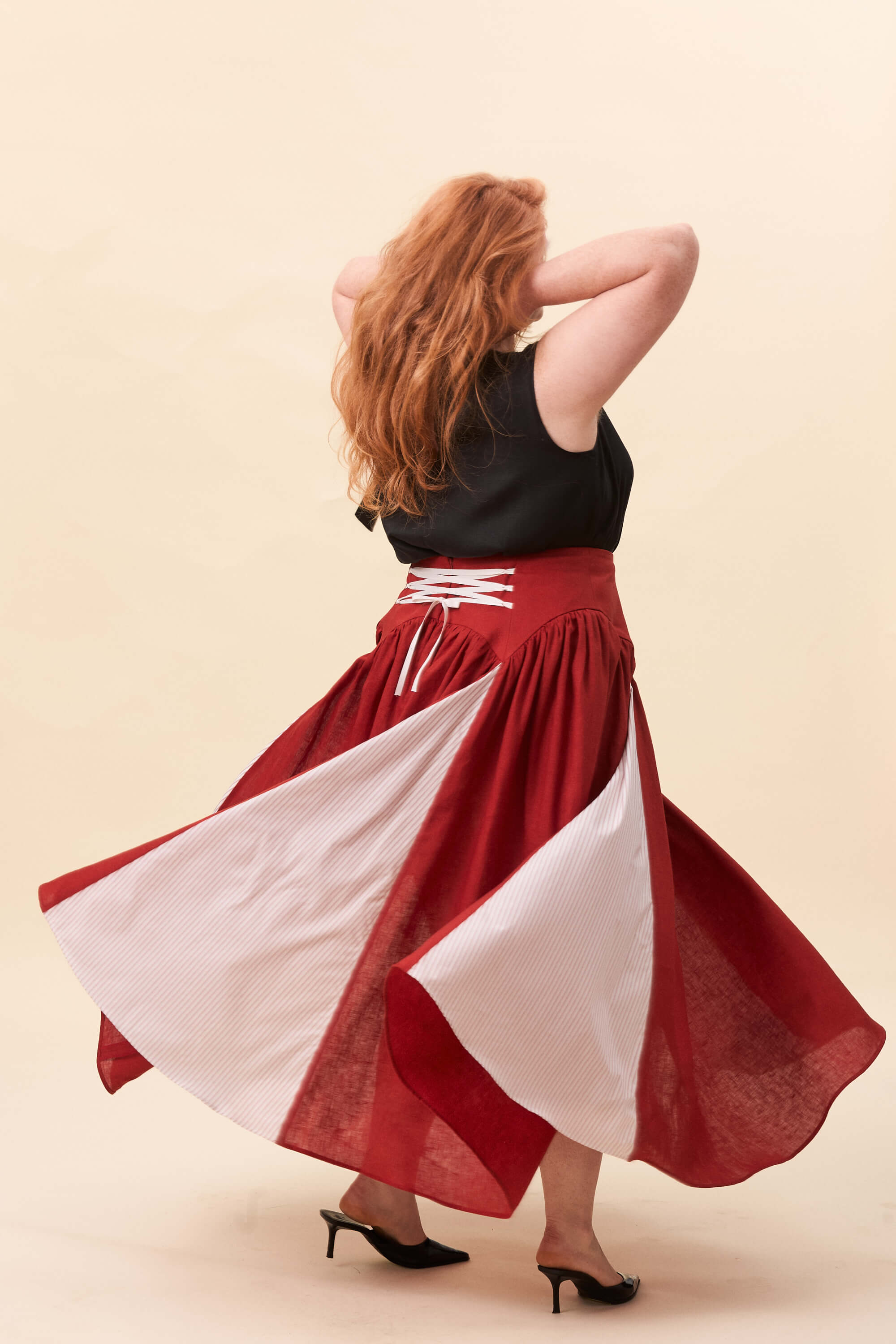 Spring 2026 Cordelia Gray Maxi Skirt In Tomato Red 3 Cordelia Gray Maxi Skirt In Tomato Red Cordelia Gray maxi skirt in tomato red The waist holds a fitted structure before releasing into a full, gathered skirt. Contrasting panels at the front and back shape the silhouette, introducing variation and rhythm as the garment moves.