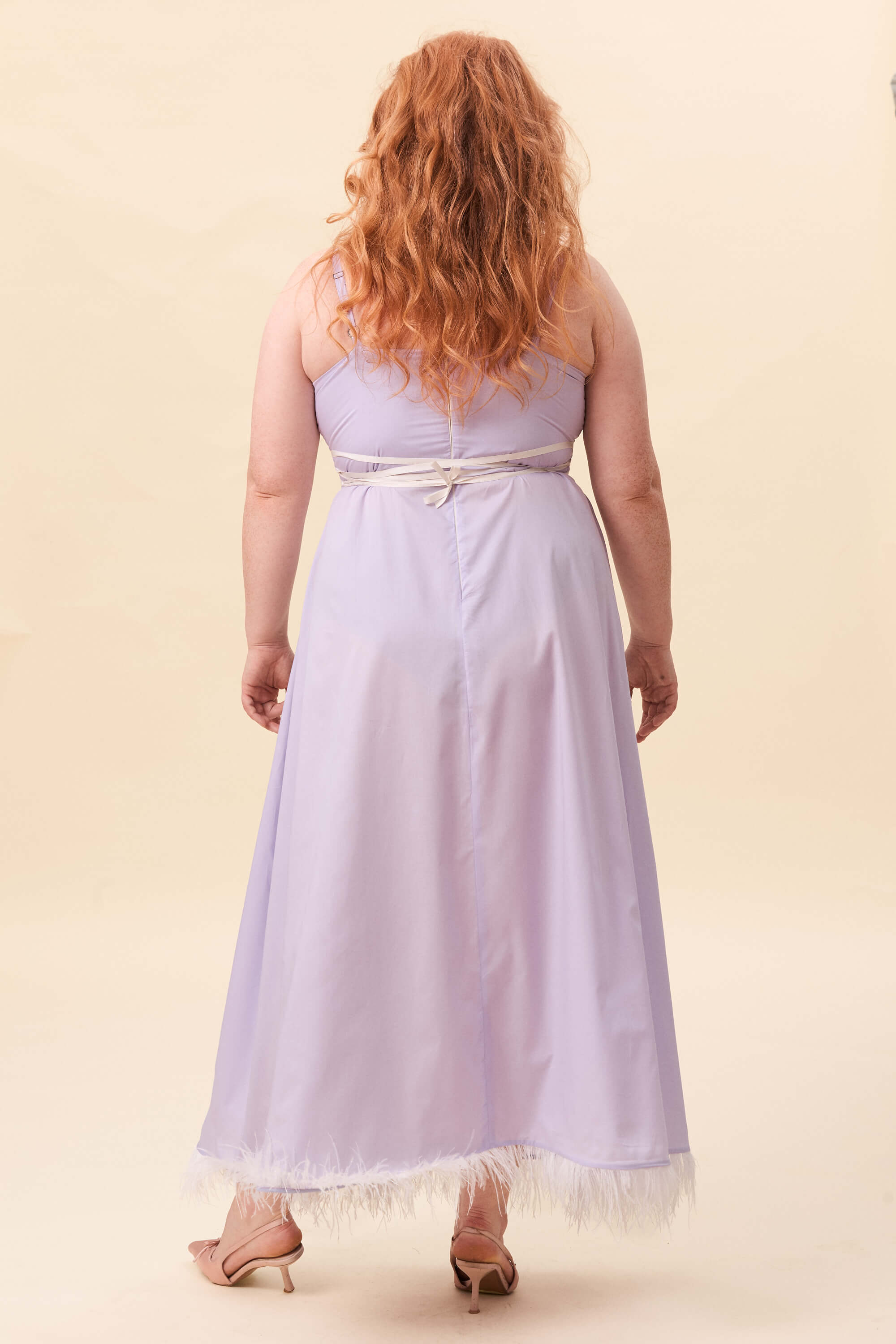 Spring 2026 Gone Girl Slip Dress In Lavender Voille 7 Gone Girl Slip Dress In Lavender Voille Gone Girl slip dress in lavender voille An elongated silhouette designed to move with ease. The focus gathers at the bust, to a sculptural rose from which two slender lines fall, guiding the eye downward and wrapping into a corset at the back. Form shaped through tension and release.