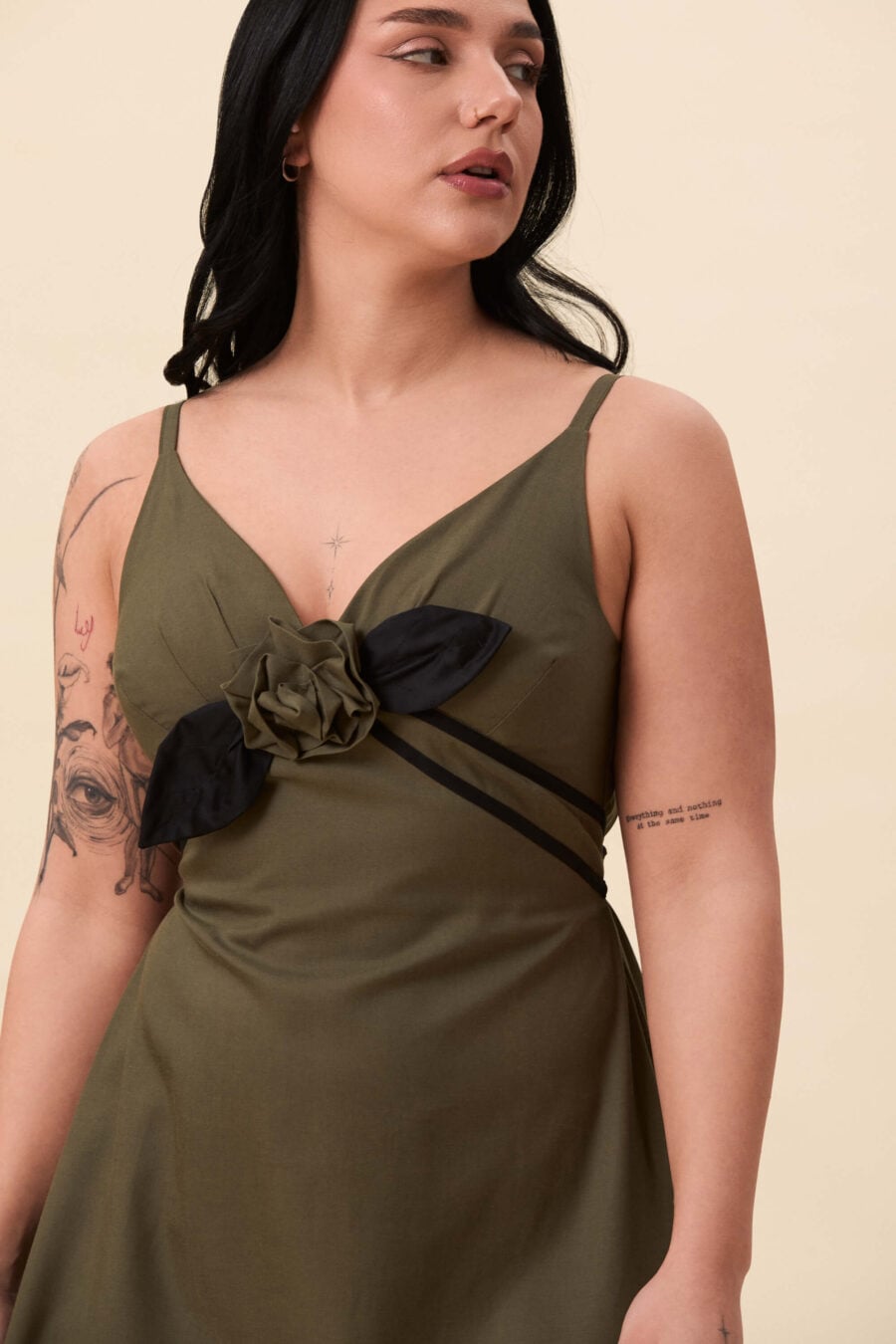 Gone Girl slip dress in olive green - An elongated silhouette designed to move with ease. The focus gathers at the bust, to a sculptural rose from which two slender lines fall, guiding the eye downward and wrapping into a corset at the back. Form shaped through tension and release.