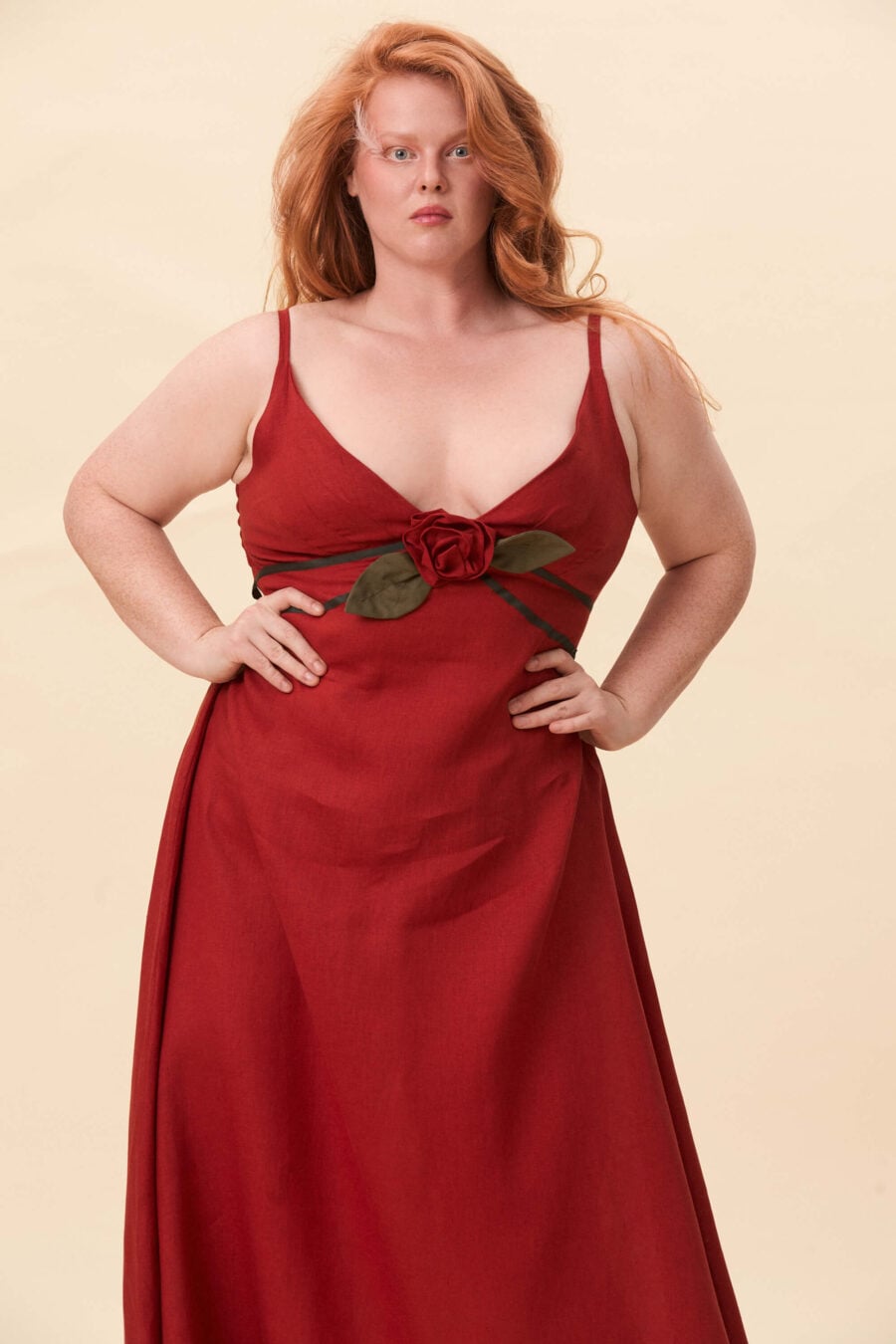 Gone Girl slip dress in tomato red - An elongated silhouette designed to move with ease. The focus gathers at the bust, to a sculptural rose from which two slender lines fall, guiding the eye downward and wrapping into a corset at the back. Form shaped through tension and release.