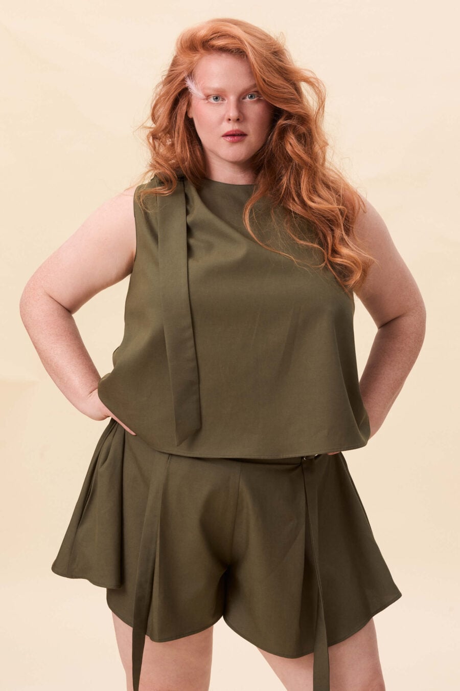 Harriet Vane top in olive green - A sleeveless top with a clean, uninterrupted front. The silhouette is relaxed, allowing it to fall naturally or be tucked for a more defined shape. A narrow tie detail sits at the side, introducing structure without altering the clean lines.