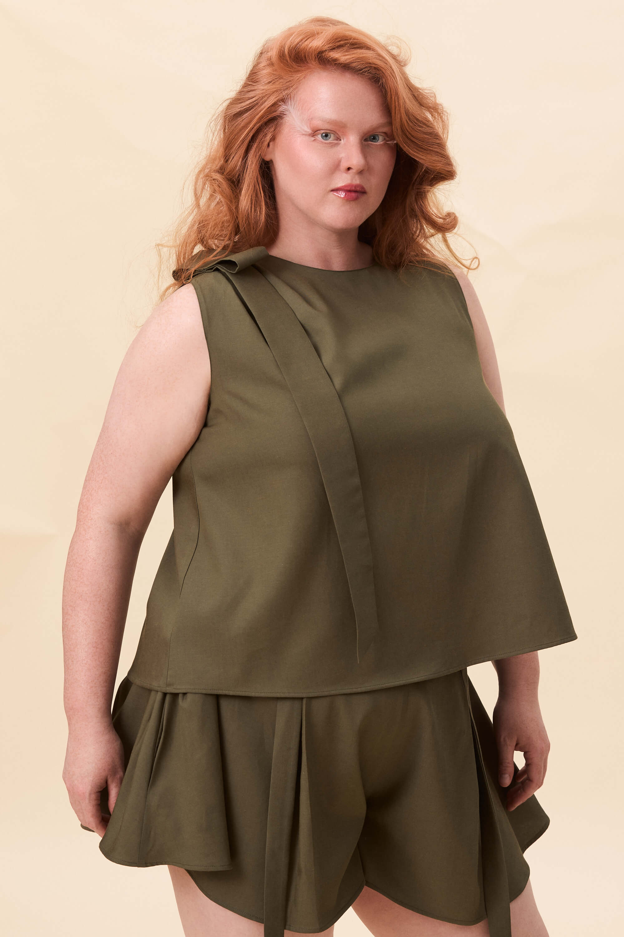 Spring 2026 Harriet Vane Top In Olive Green 2 Harriet Vane Top In Olive Green Harriet Vane top in olive green A sleeveless top with a clean, uninterrupted front. The silhouette is relaxed, allowing it to fall naturally or be tucked for a more defined shape. A narrow tie detail sits at the side, introducing structure without altering the clean lines.