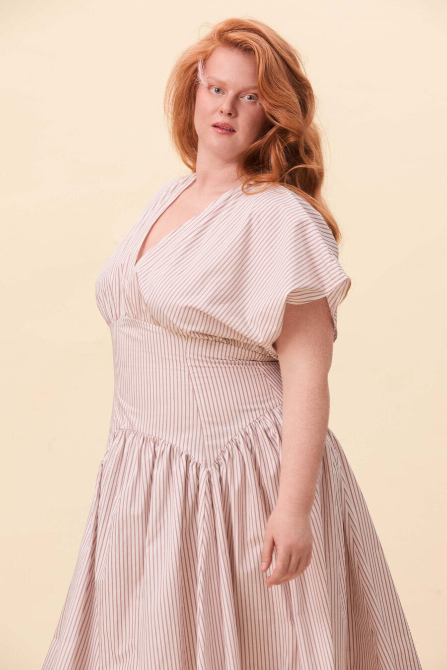 The defined waist and open neckline offer a sense of direction, while the volume of the skirt leaves space for the body to exist as it is.