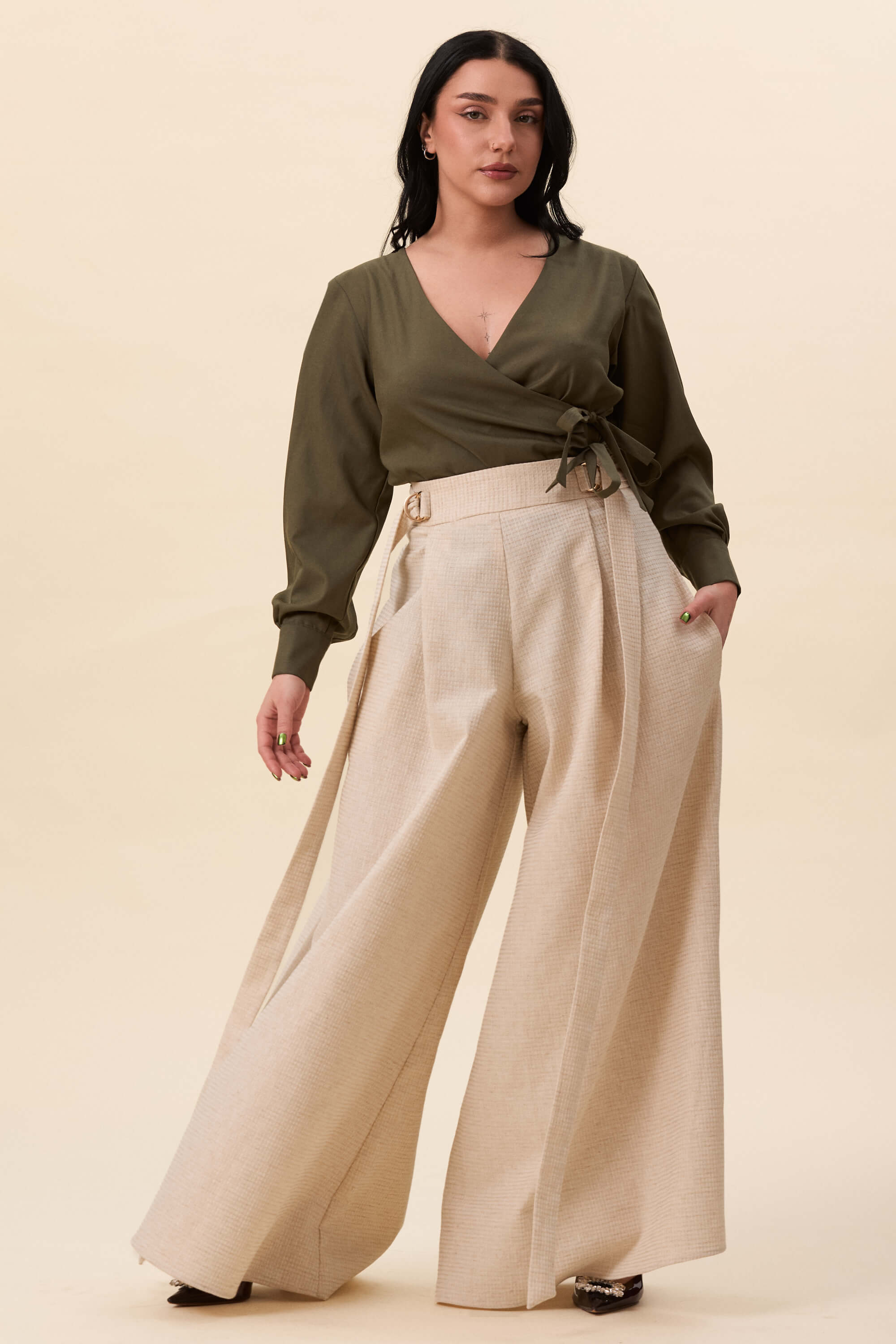 Spring 2026 Strong Poison Wrap Shirt In Olive Green 2 Strong Poison Wrap Shirt In Olive Green Strong Poison wrap shirt in olive green A wrap shirt shaped through angled lines rather than volume. The front crosses into a sharp, pointed hem, fastening with slender ties at the side. Sleeves are softly structured, finished with extended cuffs.