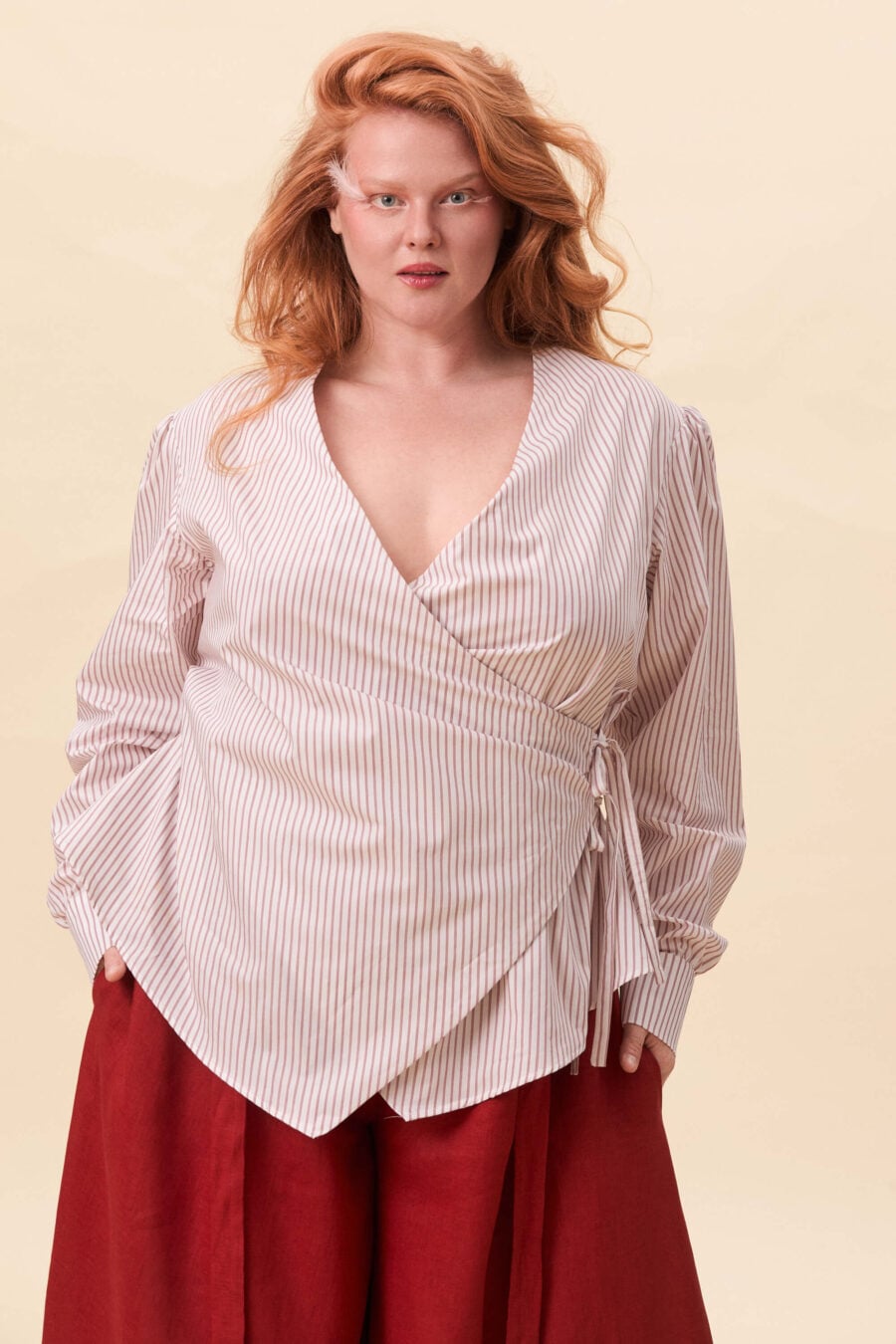 Strong Poison wrap shirt in red stripes - A wrap shirt shaped through angled lines rather than volume. The front crosses into a sharp, pointed hem, fastening with slender ties at the side. Sleeves are softly structured, finished with extended cuffs.