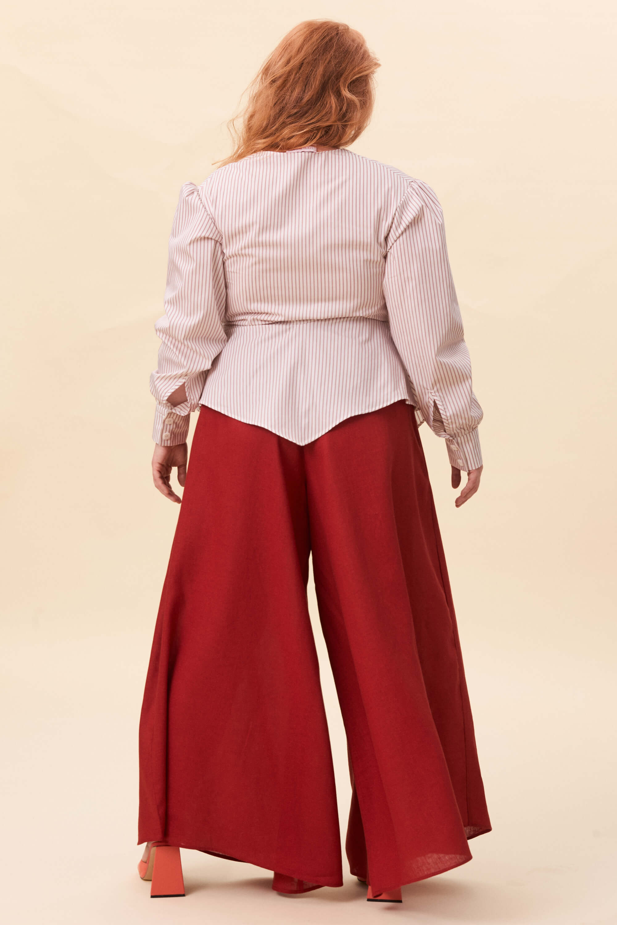 Spring 2026 Strong Poison Wrap Shirt In Red Stripes 2 Strong Poison Wrap Shirt In Red Stripes Strong Poison wrap shirt in red stripes A wrap shirt shaped through angled lines rather than volume. The front crosses into a sharp, pointed hem, fastening with slender ties at the side. Sleeves are softly structured, finished with extended cuffs.