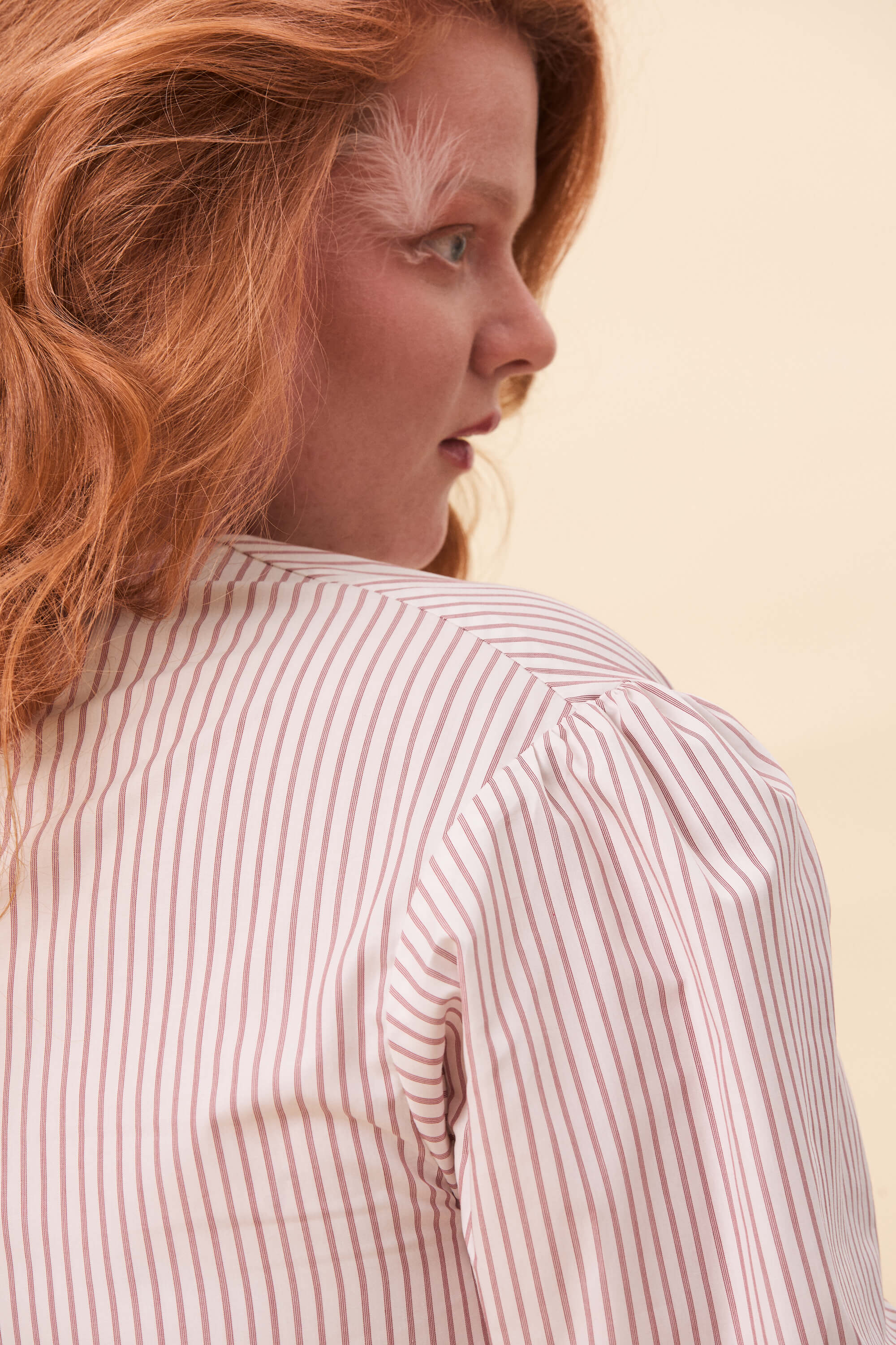 Spring 2026 Strong Poison Wrap Shirt In Red Stripes 6 Strong Poison Wrap Shirt In Red Stripes Strong Poison wrap shirt in red stripes A wrap shirt shaped through angled lines rather than volume. The front crosses into a sharp, pointed hem, fastening with slender ties at the side. Sleeves are softly structured, finished with extended cuffs.