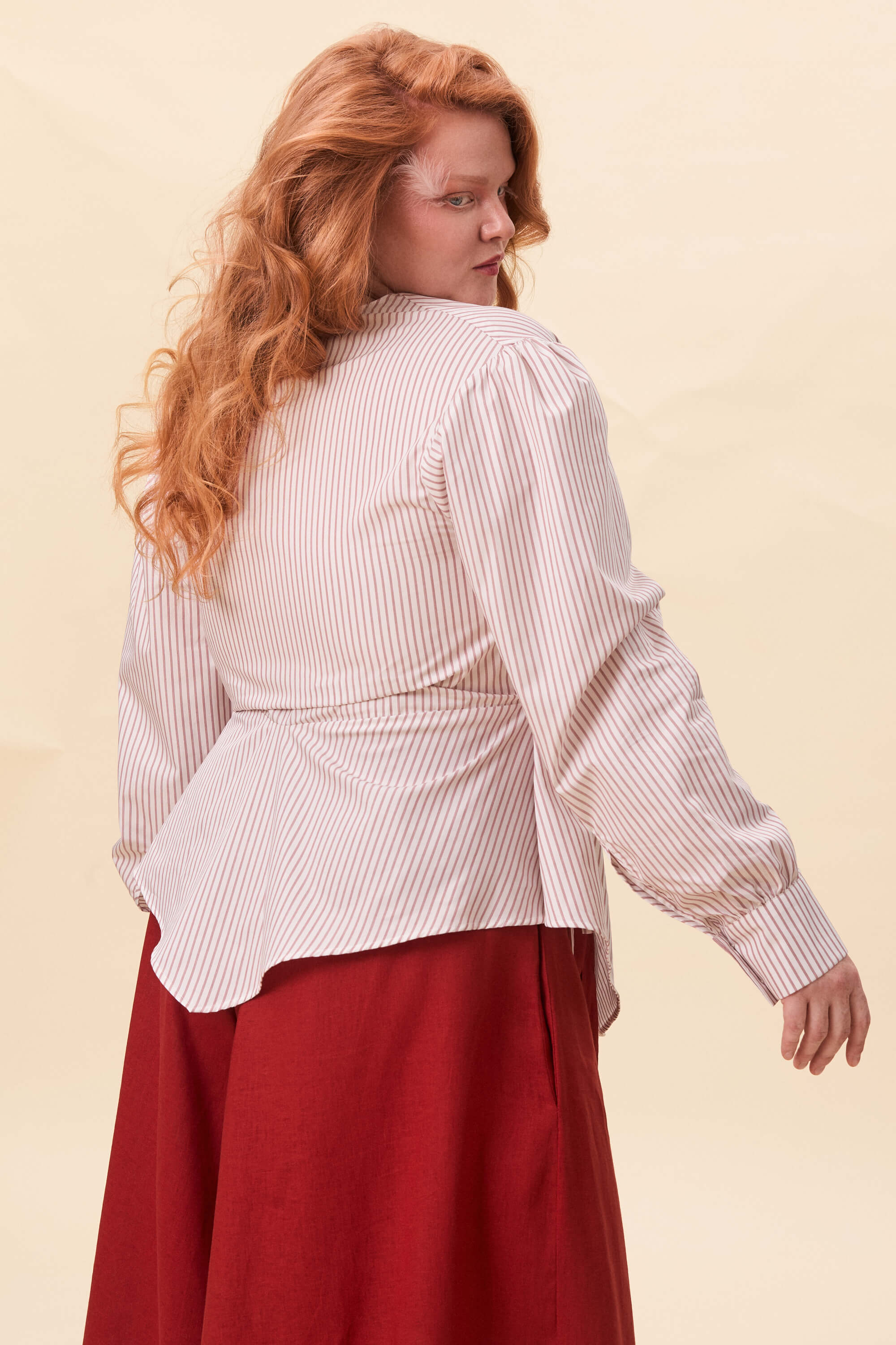 Spring 2026 Strong Poison Wrap Shirt In Red Stripes 7 Strong Poison Wrap Shirt In Red Stripes Strong Poison wrap shirt in red stripes A wrap shirt shaped through angled lines rather than volume. The front crosses into a sharp, pointed hem, fastening with slender ties at the side. Sleeves are softly structured, finished with extended cuffs.