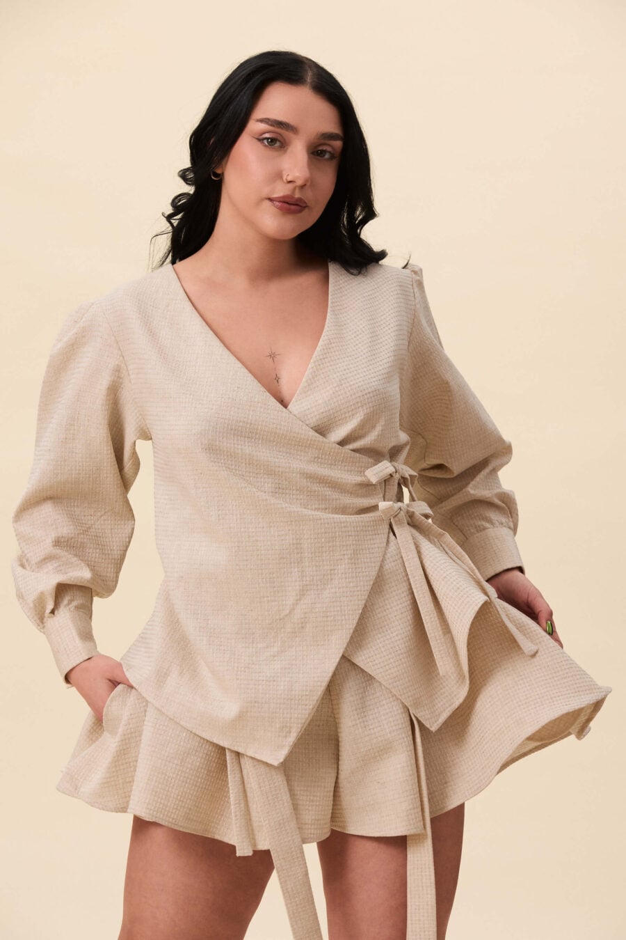 Strong Poison wrap shirt in textured beige - A wrap shirt shaped through angled lines rather than volume. The front crosses into a sharp, pointed hem, fastening with slender ties at the side. Sleeves are softly structured, finished with extended cuffs.