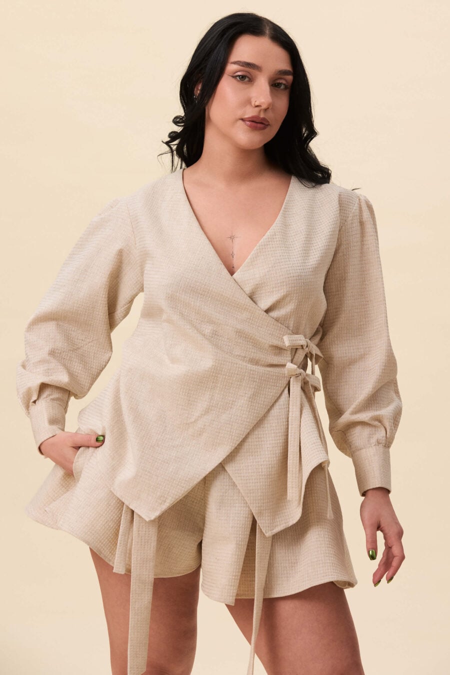 Strong Poison wrap shirt in textured beige - A wrap shirt shaped through angled lines rather than volume. The front crosses into a sharp, pointed hem, fastening with slender ties at the side. Sleeves are softly structured, finished with extended cuffs.