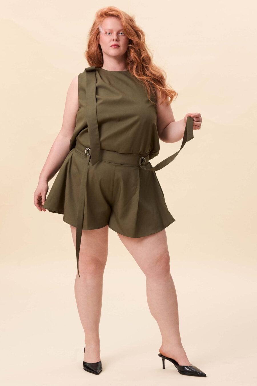 You Will Know Me shorts in olive green - Shorts cut with a structured waist and full, skirt-like volume through the leg. The waist is defined by an integrated belt, fastening through D-rings for adjustable fit. The shape opens freely, creating movement with every step.