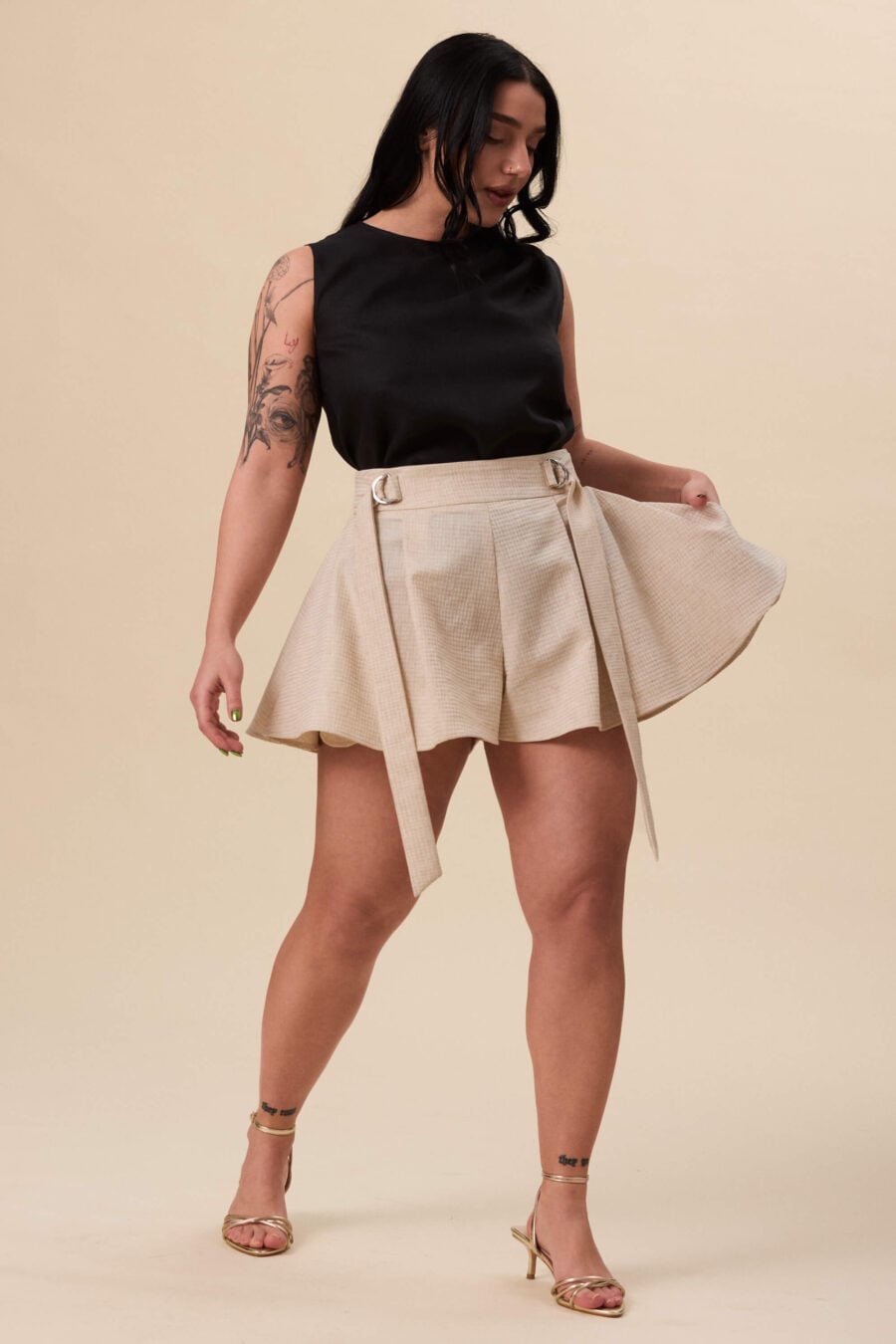 You Will Know Me shorts in textured beige - Shorts cut with a structured waist and full, skirt-like volume through the leg. The waist is defined by an integrated belt, fastening through D-rings for adjustable fit. The shape opens freely, creating movement with every step.